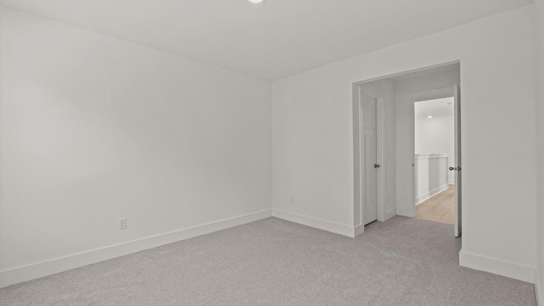 Elegant bedroom retreat featuring soft carpeting and a thoughtfully designed walk-in closet