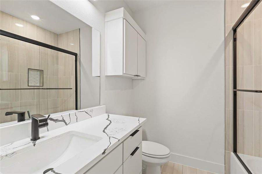 Full bath featuring toilet, baseboards, and vanity