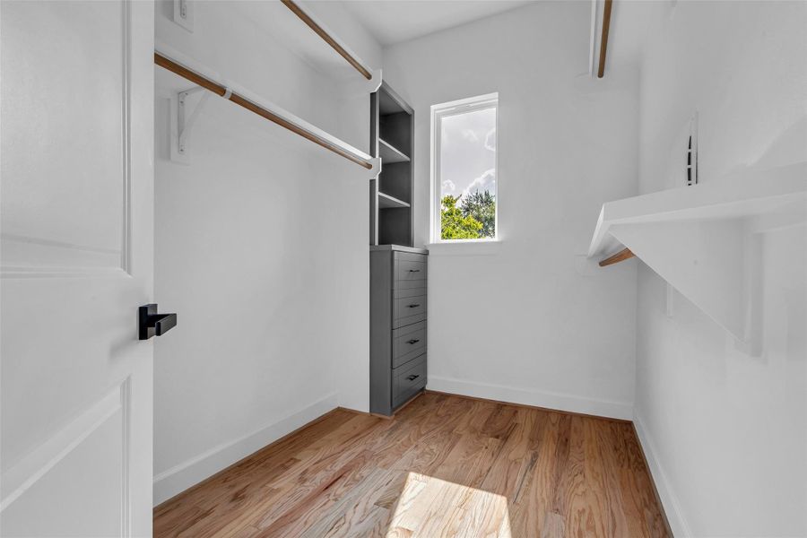 Discover ultimate organization in this walk-in closet, boasting sleek built-in shelving and drawers for effortless style and functionality. Discover ultimate organization in this walk-in closet, boasting sleek built-in shelving and drawers for effortless style and functionality.