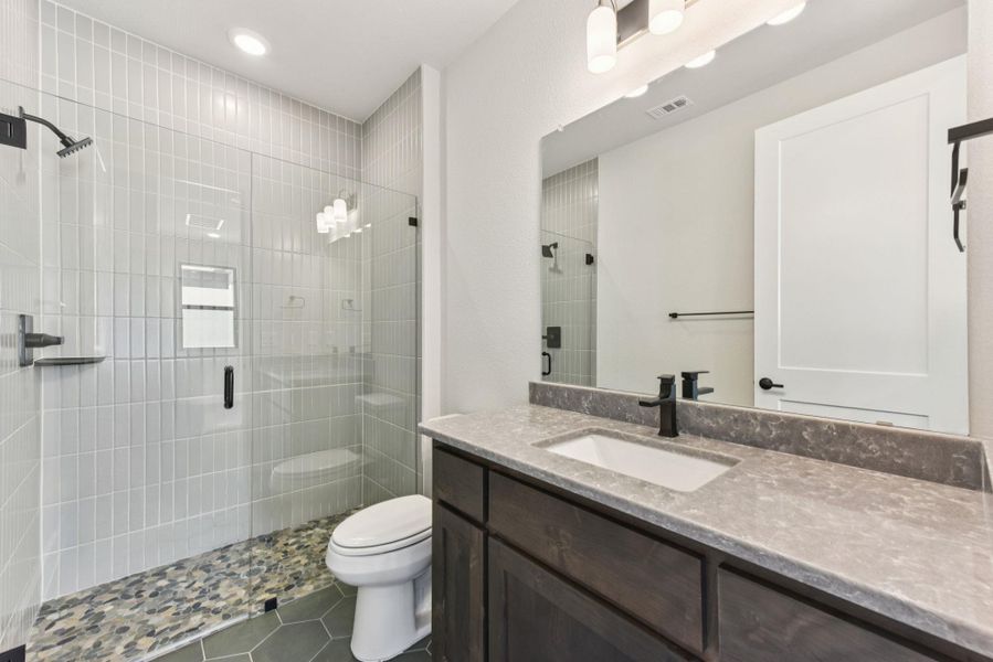 Bathroom with dark tile patterned flooring, vanity, and a stall shower Bathroom with dark tile patterned flooring, vanity, and a stall shower