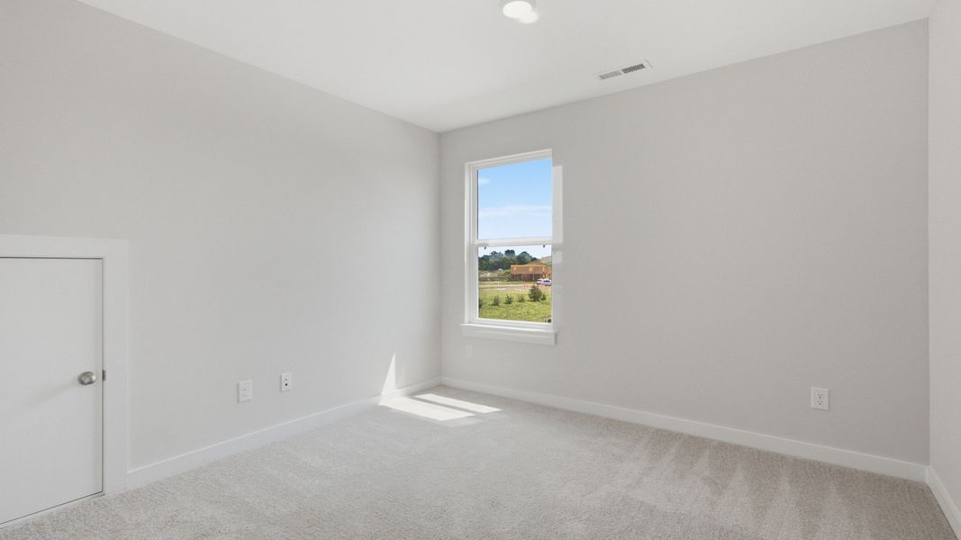 Separate secondary bedroom with window and small door for storage