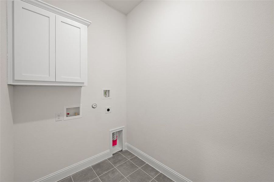 Laundry room featuring gas dryer hookup, tile patterned flooring, hookup for a washing machine, hookup for an electric dryer, and cabinet space Laundry room featuring gas dryer hookup, tile patterned flooring, hookup for a washing machine, hookup for an electric dryer, and cabinet space