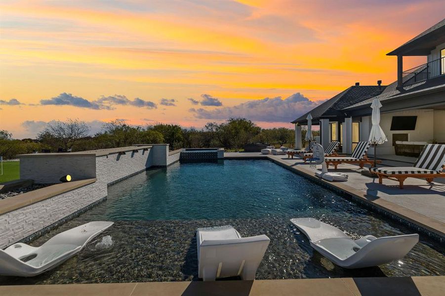 View of pool featuring a patio area, a pool with connected hot tub, and a balcony View of pool featuring a patio area, a pool with connected hot tub, and a balcony