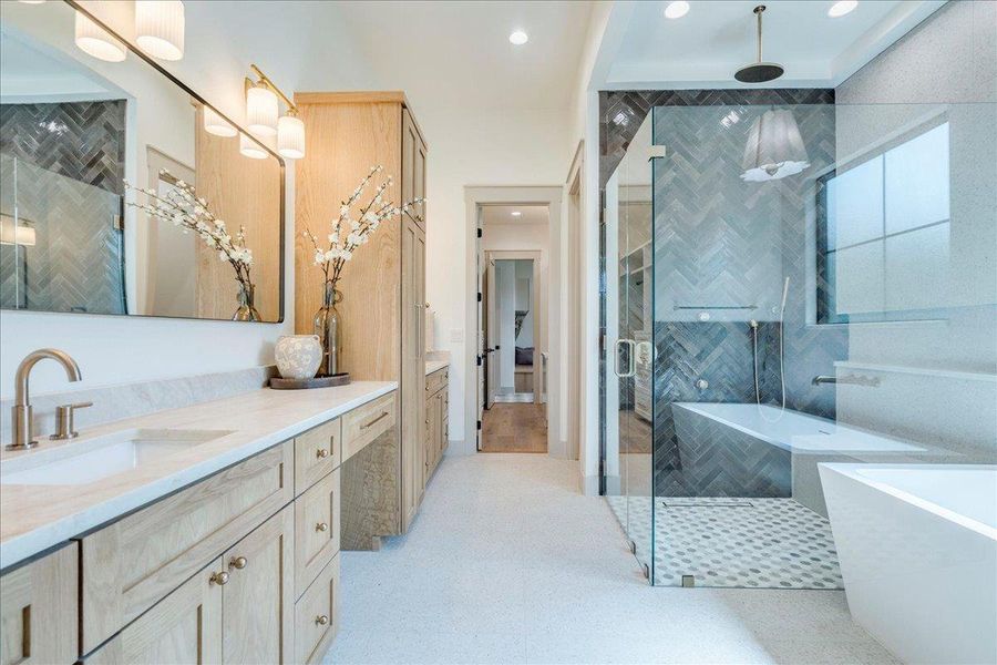 Indulge in this well-appointed bathroom featuring a standalone tub, glass-enclosed shower, and a long dual vanity.