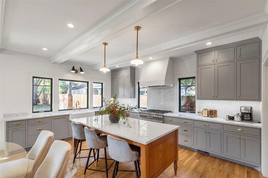 Kitchen featuring tasteful backsplash, plenty of natural light, light wood-type flooring, and custom range hood