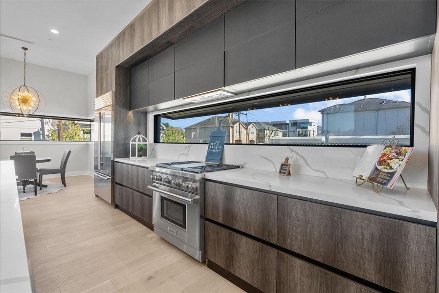 This modern kitchen features sleek cabinetry, high-end appliances, and a large window offering abundant natural light. The open layout connects seamlessly to a dining area, creating a spacious and inviting atmosphere. This modern kitchen features sleek cabinetry, high-end appliances, and a large window offering abundant natural light. The open layout connects seamlessly to a dining area, creating a spacious and inviting atmosphere.