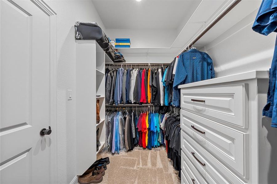 Walk-in closet with extensive built-in shelving, cabinetry, and space on both sides. Walk-in closet with extensive built-in shelving, cabinetry, and space on both sides.