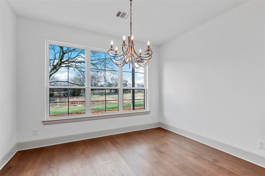 Unfurnished dining area with an inviting chandelier and wood-type flooring