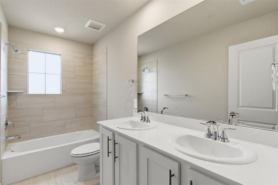 The bathroom features a double vanity with two sinks and white cabinetry