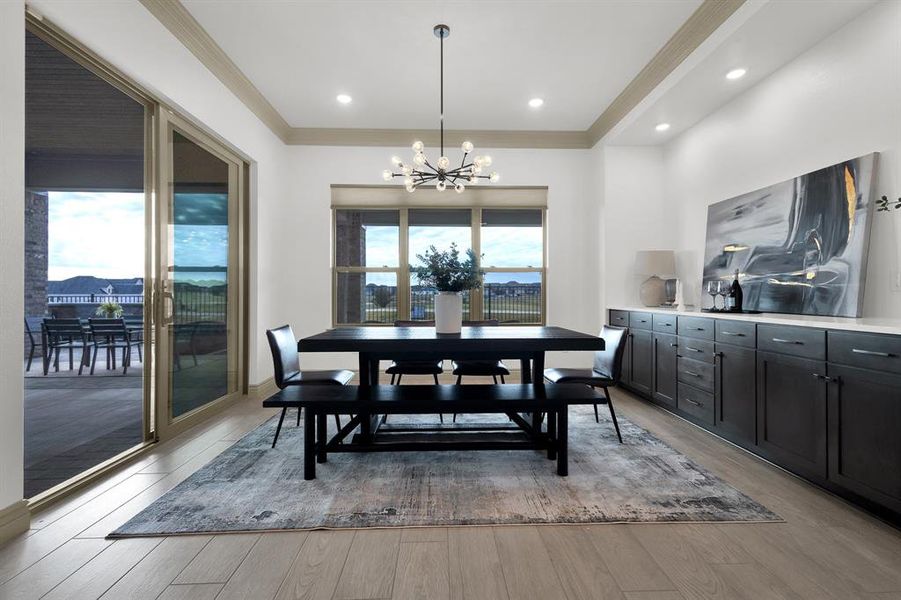 Dining room featuring crown molding, light wood finished floors, a chandelier, and recessed lighting
