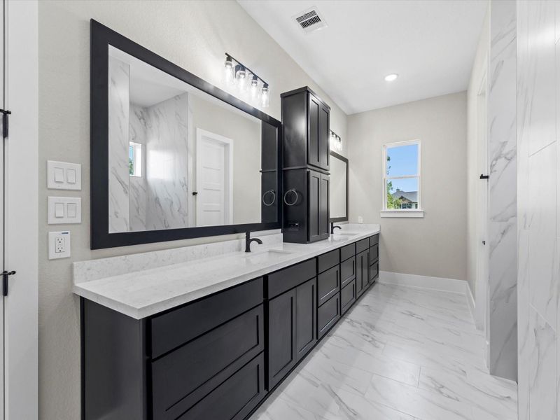 Primary bathroom with double sinks, framed mirrors and ample cabinetry. Primary bathroom with double sinks, framed mirrors and ample cabinetry.