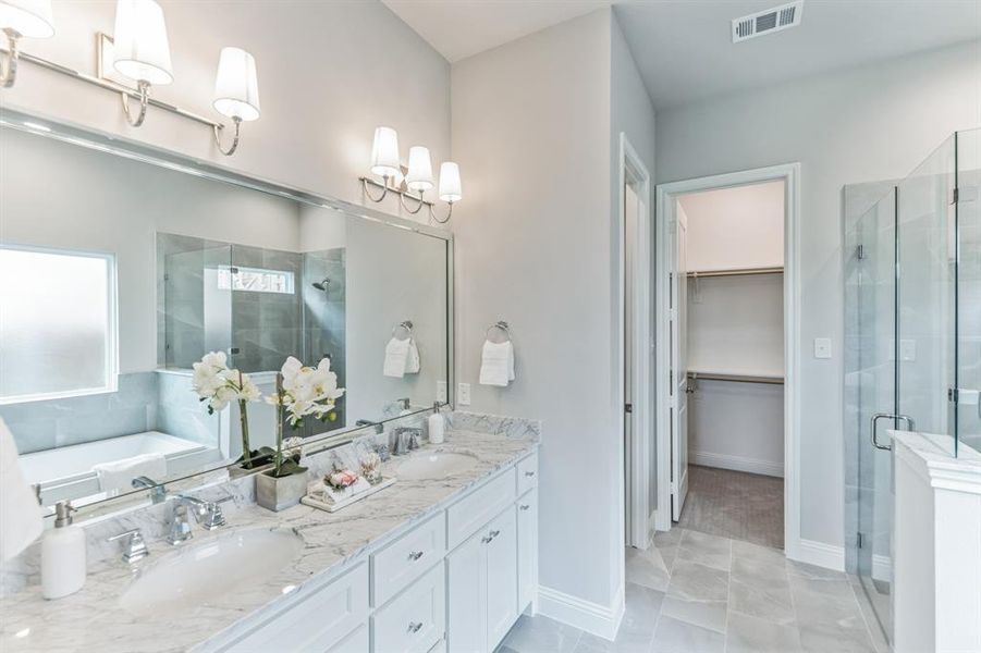 Bathroom featuring double vanity, shower with separate bathtub, and tile patterned floors