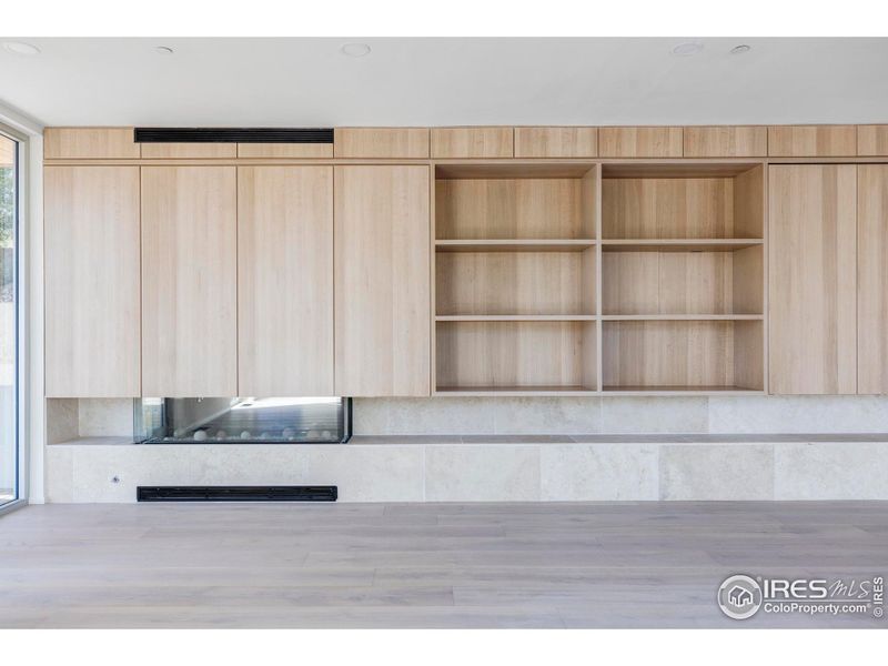 A wall of custom hickory built-ins, a 60-inch gas fireplace and multiple expansive view decks flanks the sprawling great room.