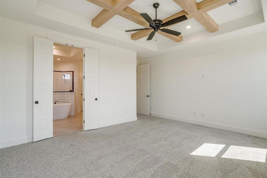 Unfurnished bedroom with ensuite bathroom, light carpet, and ceiling fan