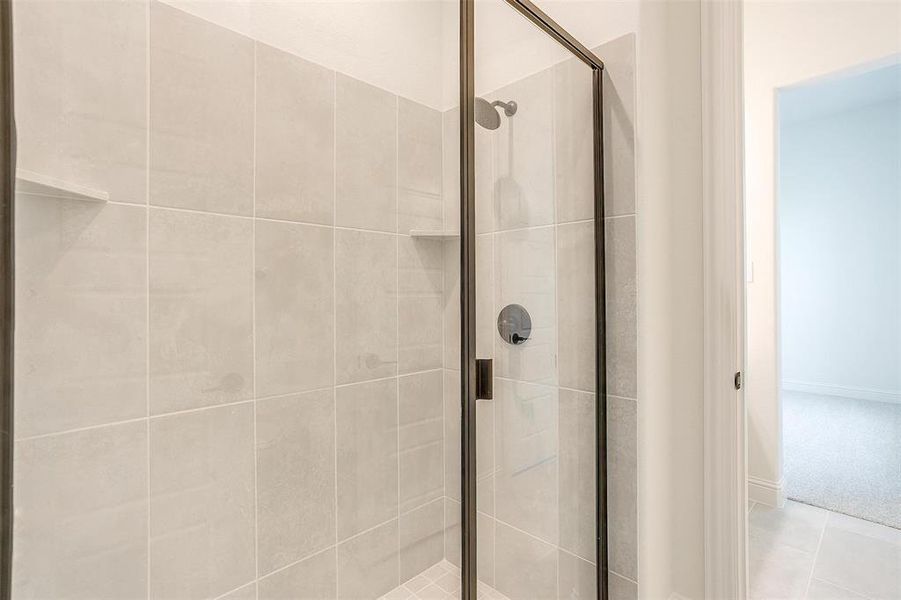 Bathroom featuring tile patterned flooring and a shower with door