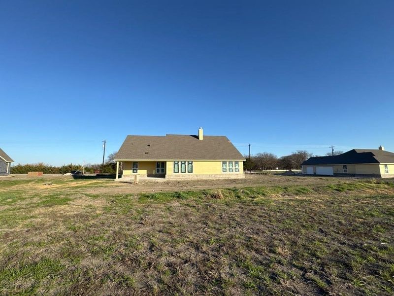 Rear view of house featuring a chimney and a patio Rear view of house featuring a chimney and a patio