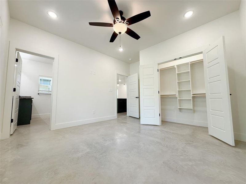 Unfurnished bedroom with finished concrete flooring, baseboards, a ceiling fan, and recessed lighting Unfurnished bedroom with finished concrete flooring, baseboards, a ceiling fan, and recessed lighting
