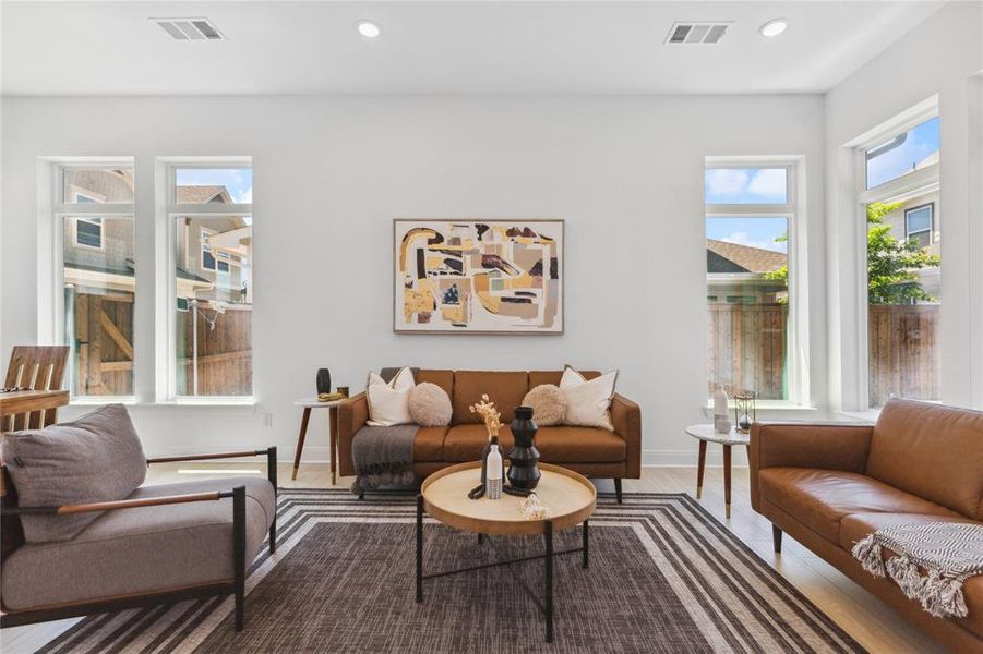 Living room with baseboards, wood finished floors, visible vents, and recessed lighting Living room with baseboards, wood finished floors, visible vents, and recessed lighting