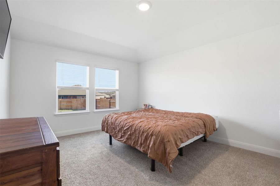 Carpeted room with white walls, two windows, and a flush-mount ceiling light