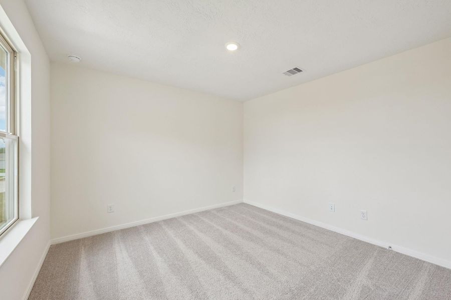 This secondary bedroom offers comfort and style with plush carpeting, neutral paint tones, recessed lighting, large windows, and a generously sized closet. This secondary bedroom offers comfort and style with plush carpeting, neutral paint tones, recessed lighting, large windows, and a generously sized closet.