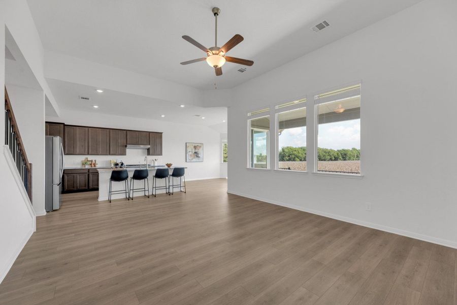 Living room featuring recessed lighting, ceiling fan, light wood-style flooring, and stairway Living room featuring recessed lighting, ceiling fan, light wood-style flooring, and stairway