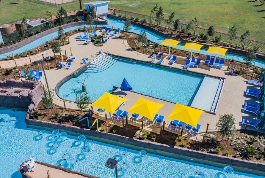Aerial view of the resort-style backyard, featuring a sprawling lazy river, sparkling wave pool, and a dedicated family swimming area.