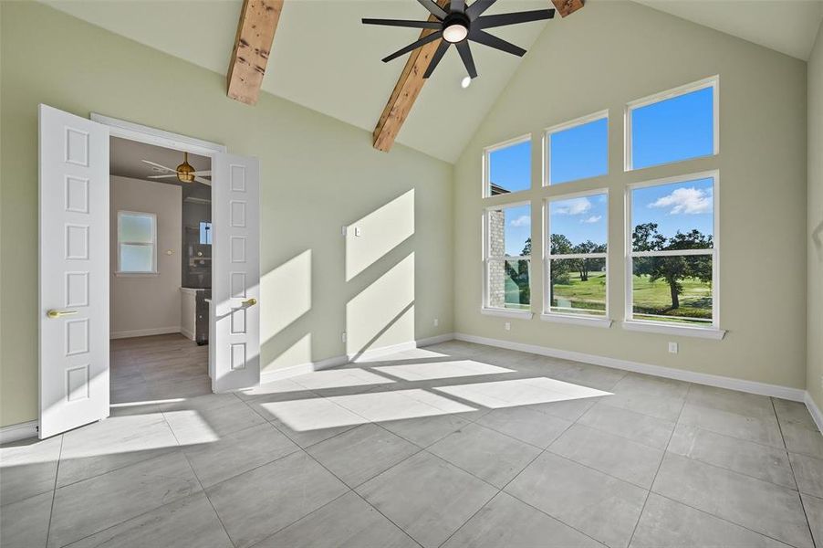 Unfurnished room featuring ceiling fan, high vaulted ceiling, light tile patterned floors, and beamed ceiling Unfurnished room featuring ceiling fan, high vaulted ceiling, light tile patterned floors, and beamed ceiling