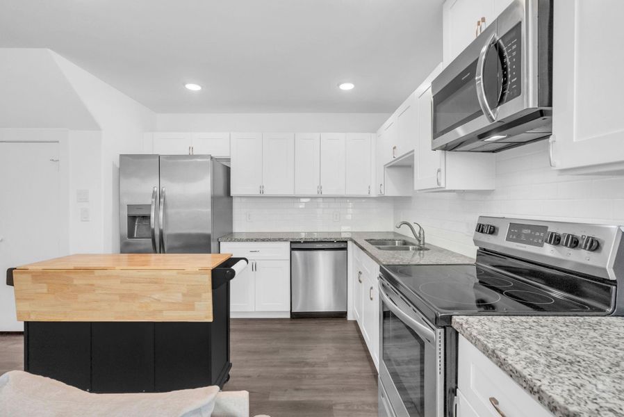 Meticulously maintained modern kitchen features sleek stainless steel appliances with built in microwave, white cabinetry, granite countertops. The space is well-lit with recessed lighting, offering a clean and inviting atmosphere. Meticulously maintained modern kitchen features sleek stainless steel appliances with built in microwave, white cabinetry, granite countertops. The space is well-lit with recessed lighting, offering a clean and inviting atmosphere.