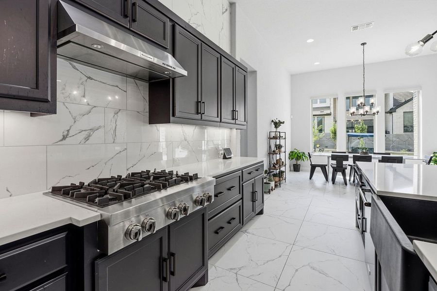 A well-lit kitchen with a modern design, featuring dark cabinetry and light-colored countertops. A well-lit kitchen with a modern design, featuring dark cabinetry and light-colored countertops.
