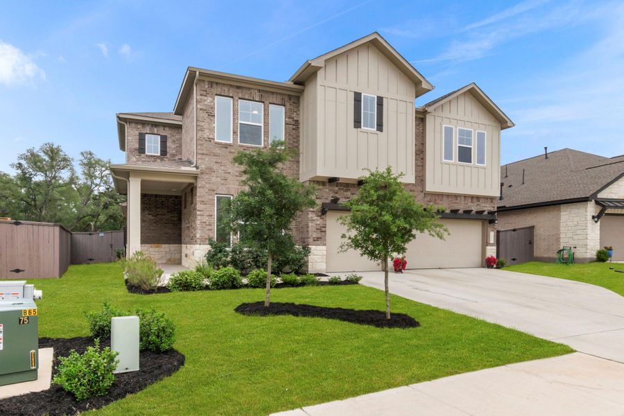 Two-story residence featuring a brick and board-and-batten facade with white trim