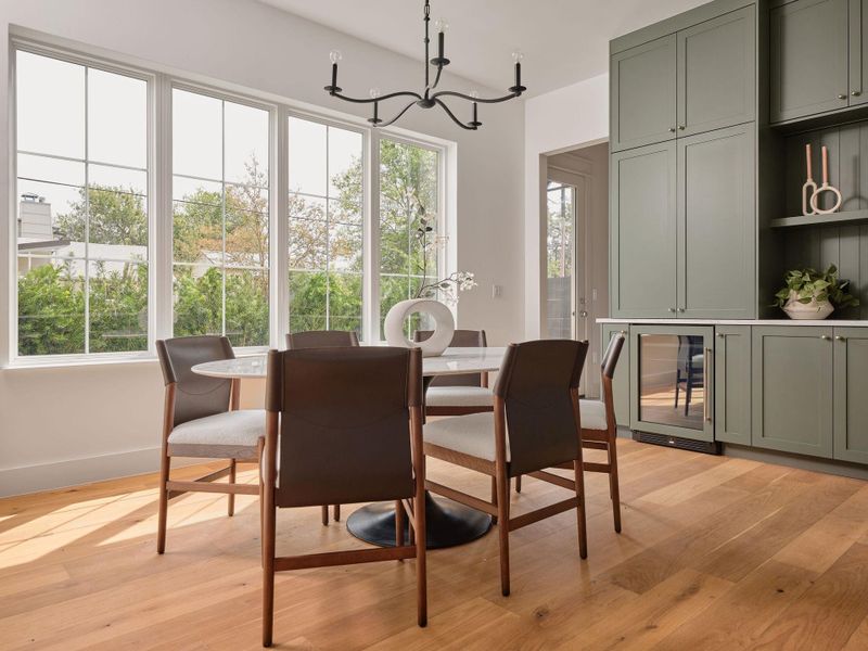 Dining room with beverage cooler, light wood-style floors, and a chandelier Dining room with beverage cooler, light wood-style floors, and a chandelier