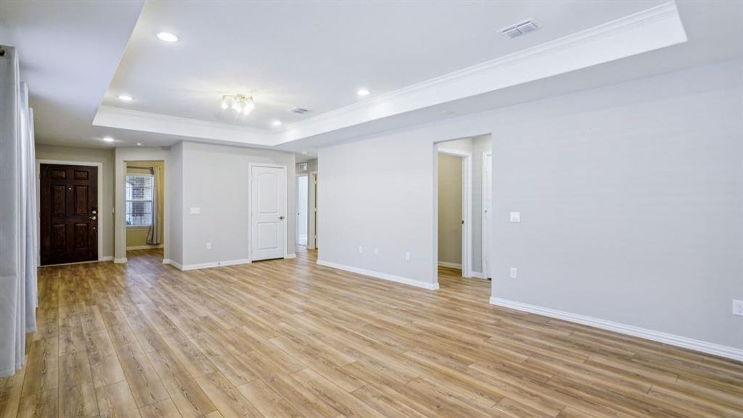 Unfurnished room with a raised ceiling, ornamental molding, recessed lighting, and light wood-style flooring Unfurnished room with a raised ceiling, ornamental molding, recessed lighting, and light wood-style flooring