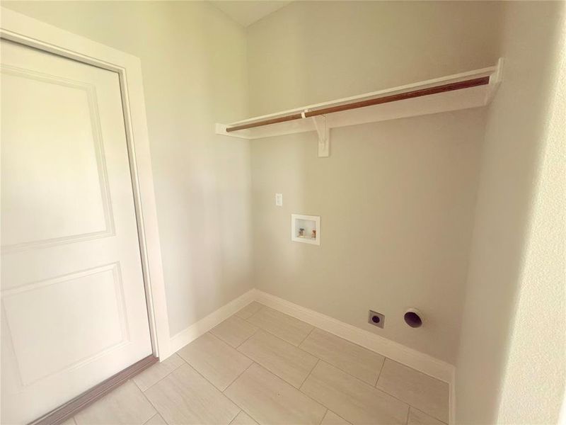 Dedicated laundry space featuring a hanging rod and shelf storage