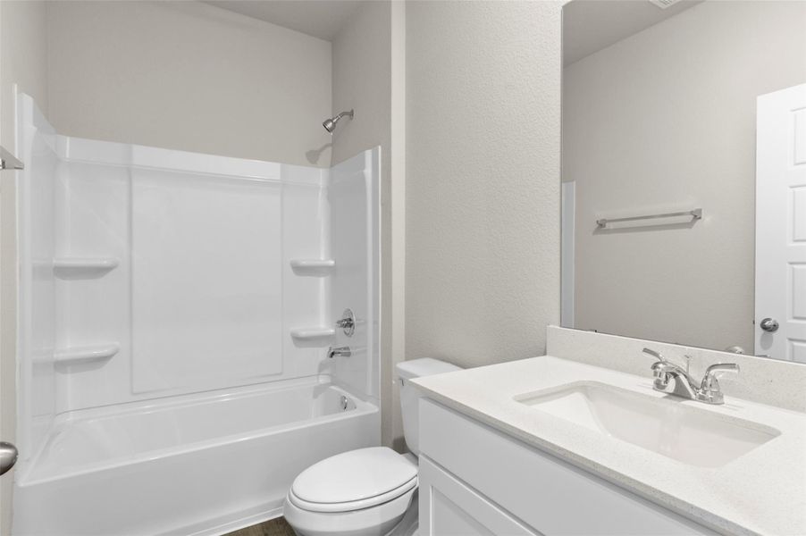 Bathroom with vanity, shower combination, and a textured wall Bathroom with vanity, shower combination, and a textured wall