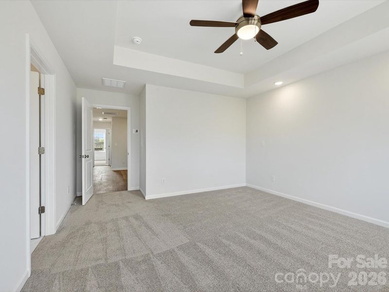Primary bedroom features tray ceiling, 2 large windows allow natural light to bathe the room. Private backyard with views of the trees