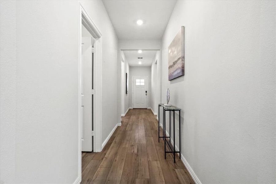 Hall featuring dark wood-style flooring and baseboards Hall featuring dark wood-style flooring and baseboards