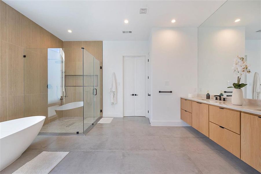 Bathroom with concrete floors, vanity, and separate shower and tub