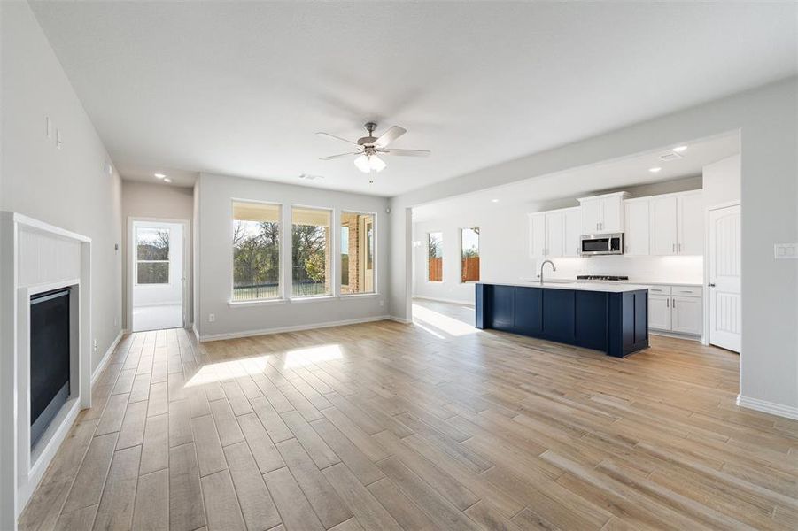 Unfurnished living room with light wood-type flooring, a fireplace, recessed lighting, and a ceiling fan
