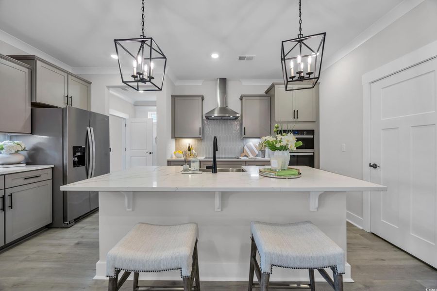 Kitchen featuring gray cabinetry, tasteful backsplash, ornamental molding, appliances with stainless steel finishes, and recessed lighting
