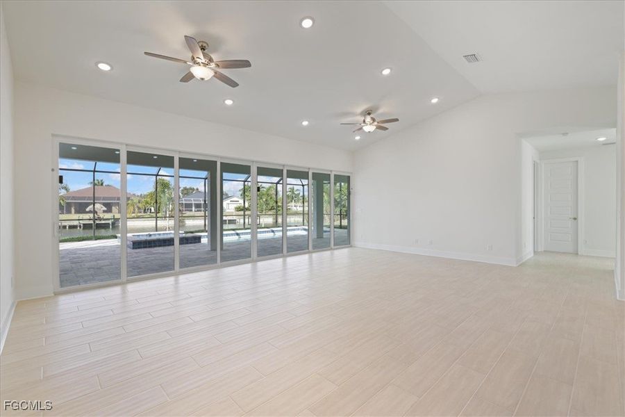 Living room featuring 24 foot slider, recessed lighting, wood finish floors, lofted ceiling, and a ceiling fan