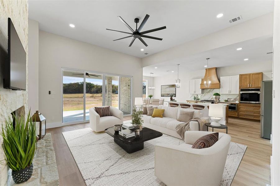 Living area featuring ceiling fan, light wood-style flooring, recessed lighting, and a fireplace Living area featuring ceiling fan, light wood-style flooring, recessed lighting, and a fireplace