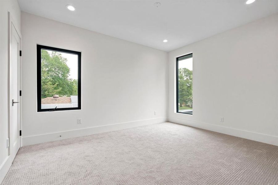 Carpeted spare room featuring recessed lighting and baseboards Carpeted spare room featuring recessed lighting and baseboards