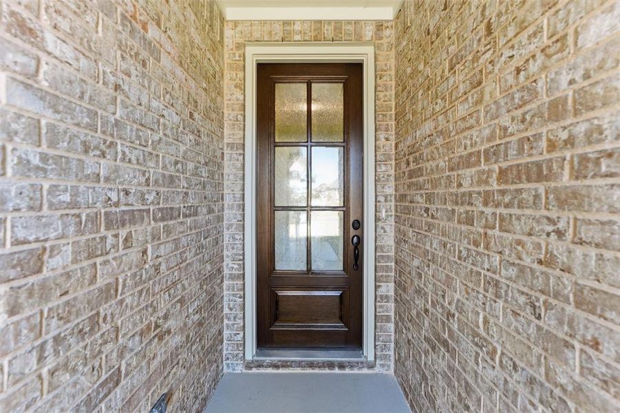 View of exterior entry featuring brick siding
