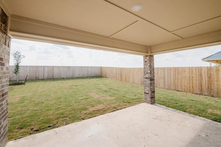 Fenced backyard with a patio area Fenced backyard with a patio area