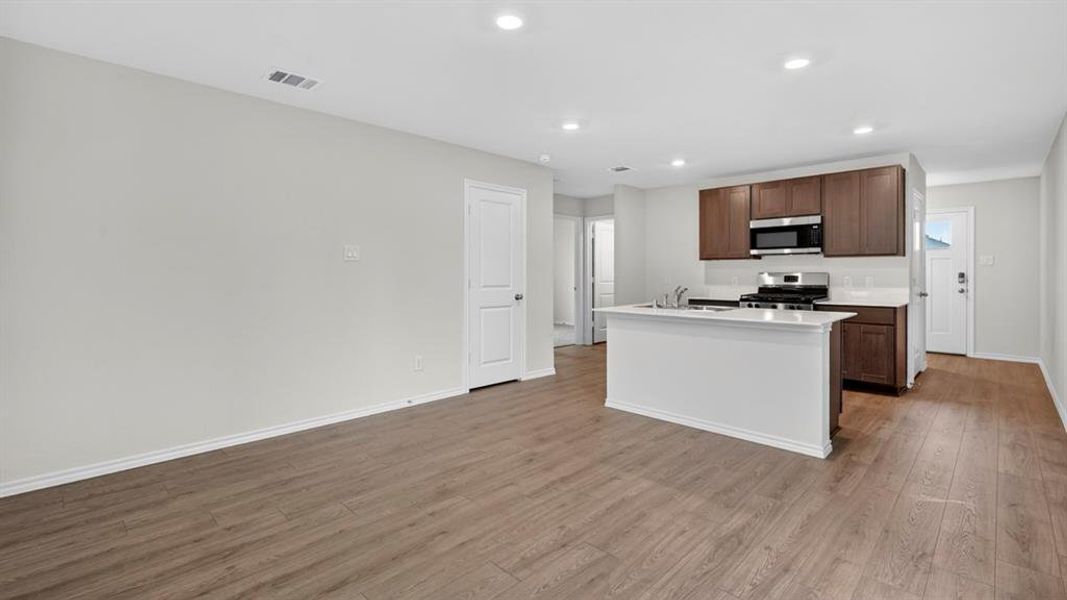 Open concept living space featuring wood-finish flooring and recessed lighting