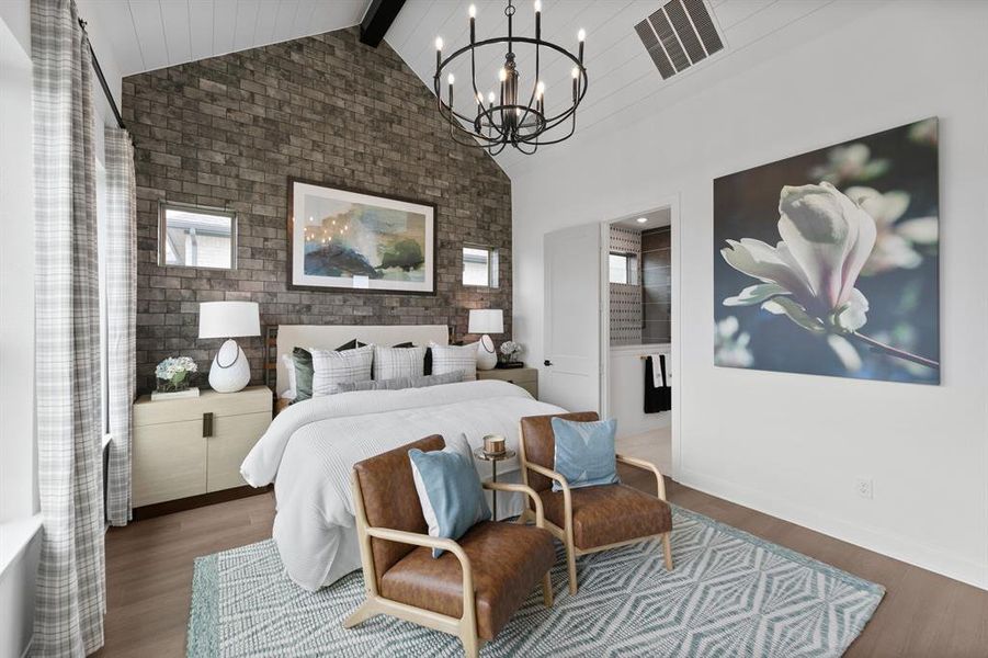 Bedroom featuring wood finished floors, brick wall, and hanging lights Bedroom featuring wood finished floors, brick wall, and hanging lights