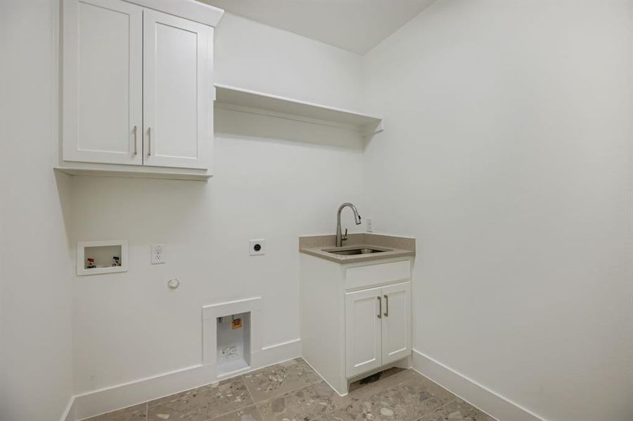 Laundry room featuring cabinet space, hookup for a gas dryer, hookup for a washing machine, hookup for an electric dryer, and light tile patterned floors