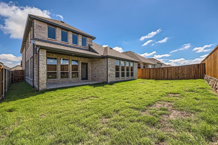 Back of property featuring a patio area and a yard