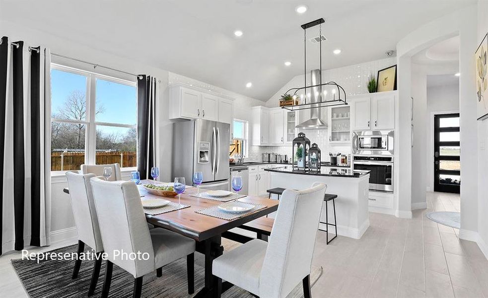 Dining space featuring lofted ceiling, plenty of natural light, and recessed lighting