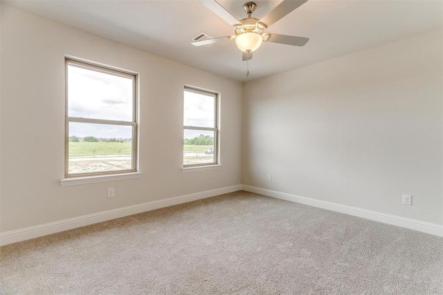 Empty room with ceiling fan and carpet flooring